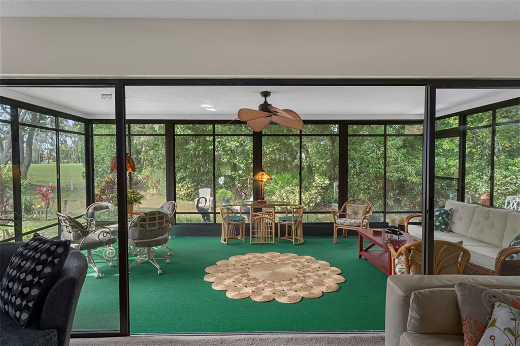 6421 Pine Meadows Drive Spring Hill, FL 34606 - Photo 16 of 61 a living room with furniture and a floor to ceiling window