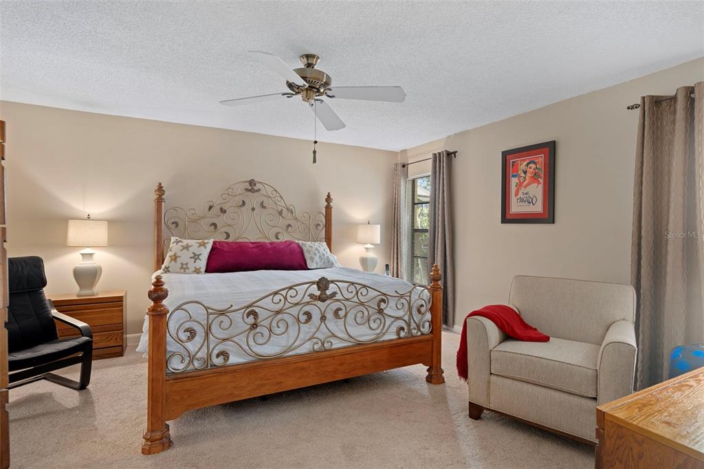 6421 Pine Meadows Drive Spring Hill, FL 34606 - Photo 29 of 61 a bedroom with a bed couches and a lamp on dresser
