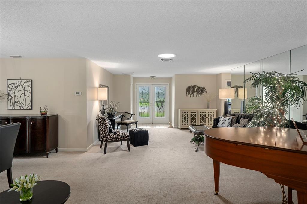 6421 Pine Meadows Drive Spring Hill, FL 34606 - Photo 5 of 61 a living room with furniture a chandelier and a large window