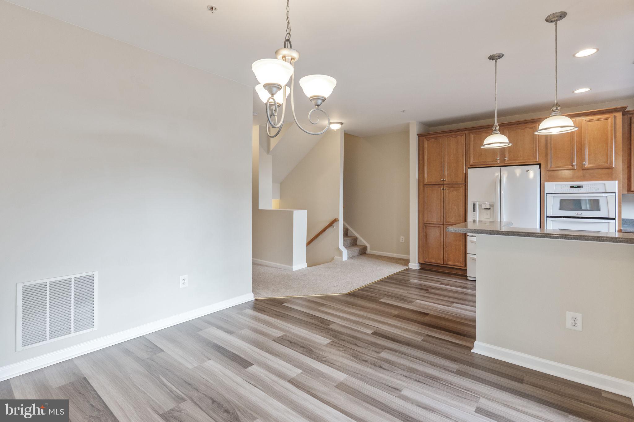 12404 B Liberty Bridge Road, Unit 12404B Fairfax, VA 22033 - Photo 11 of 43 a view of a room with wooden floor staircase and a kitchen