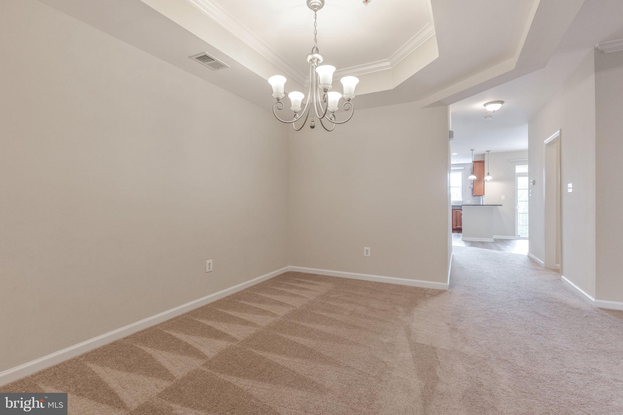 12404 B Liberty Bridge Road, Unit 12404B Fairfax, VA 22033 - Photo 19 of 43 a view of an empty room with a chandelier