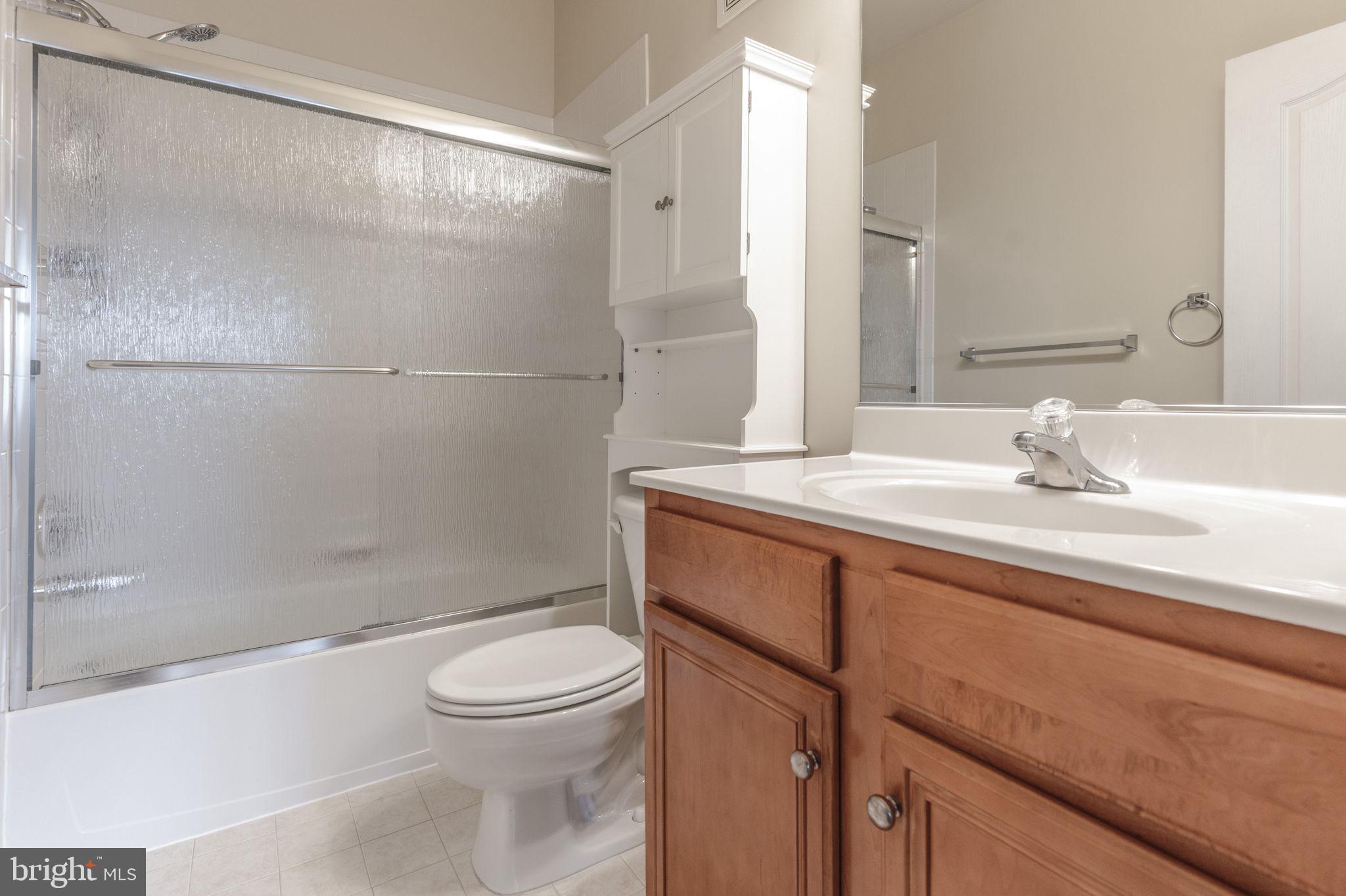 12404 B Liberty Bridge Road, Unit 12404B Fairfax, VA 22033 - Photo 24 of 43 a bathroom with a sink a toilet and shower