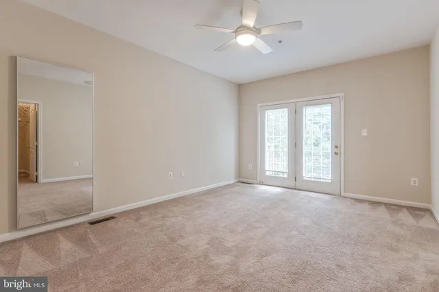 a view of an empty room with a chandelier fan