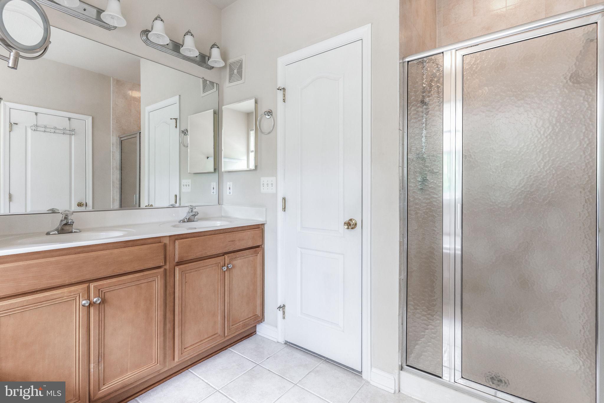 12404 B Liberty Bridge Road, Unit 12404B Fairfax, VA 22033 - Photo 37 of 43 a bathroom with a double vanity sink mirror and shower