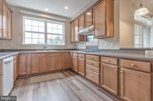 a kitchen with granite countertop stainless steel appliances and window