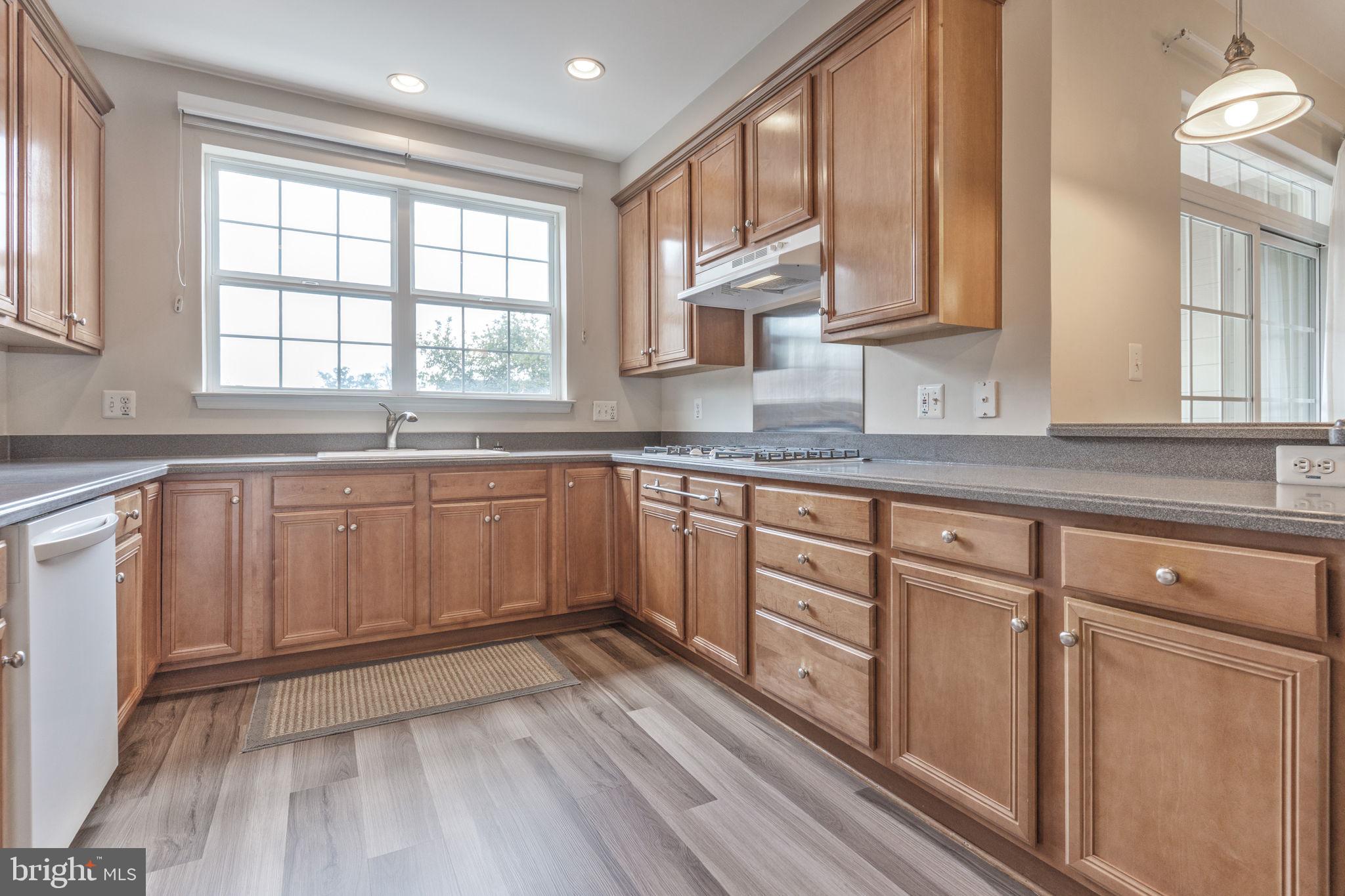 12404 B Liberty Bridge Road, Unit 12404B Fairfax, VA 22033 - Photo 6 of 43 a kitchen with sink cabinets and window