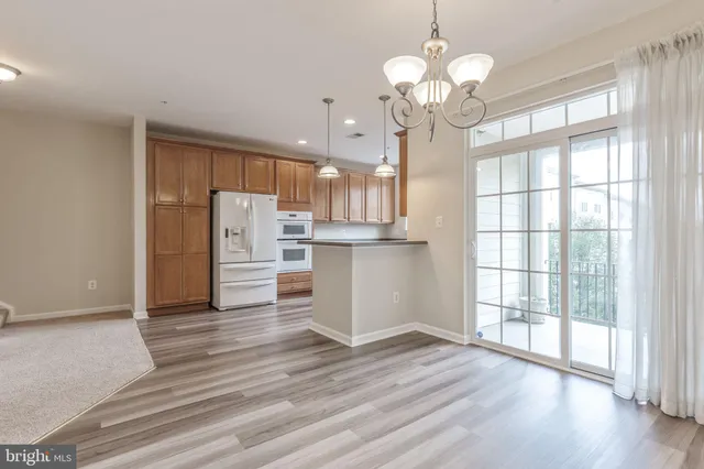 a view of a room with wooden floor staircase and a kitchen