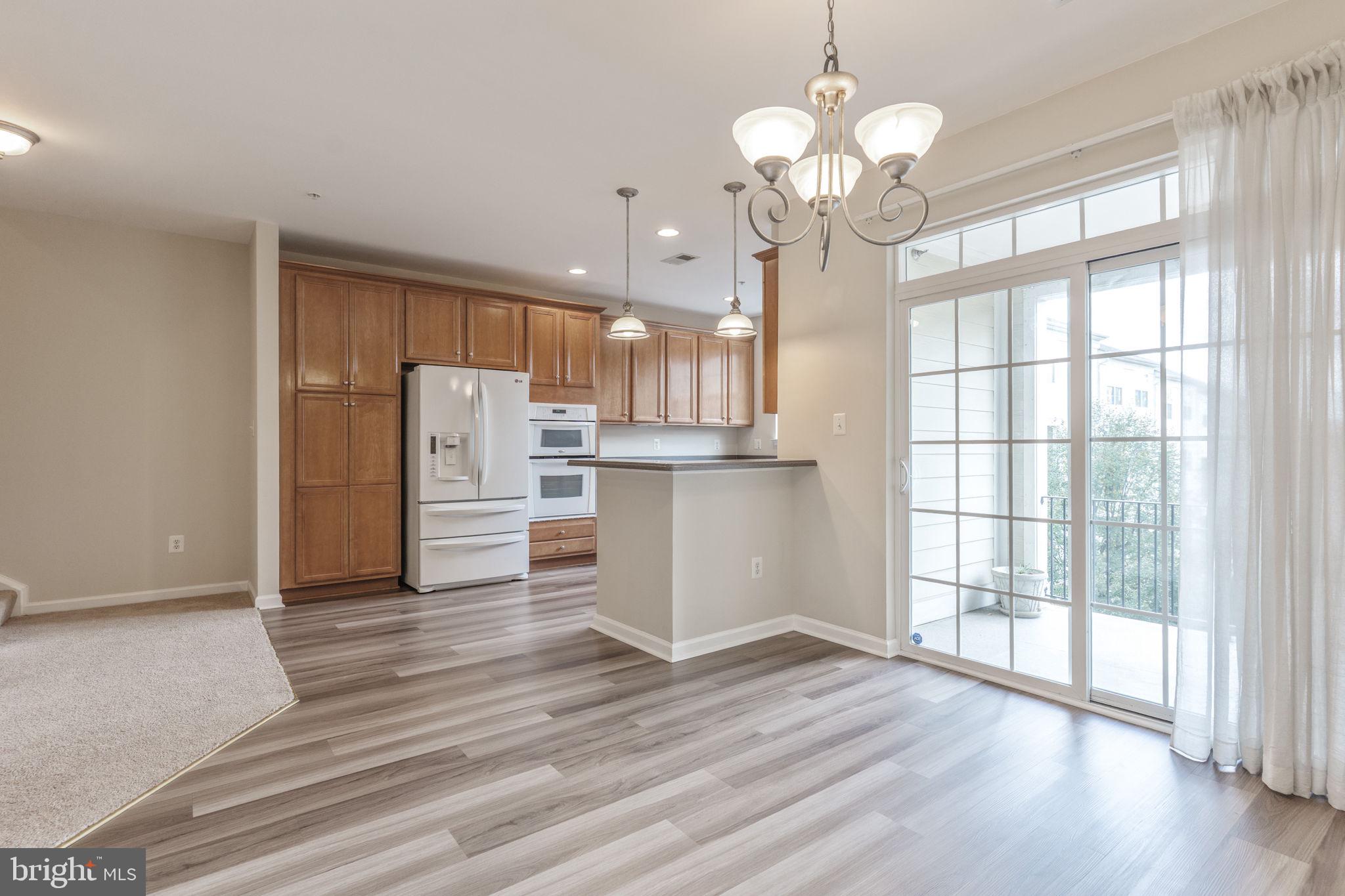 12404 B Liberty Bridge Road, Unit 12404B Fairfax, VA 22033 - Photo 10 of 43 a view of a kitchen with wooden floor and a large window