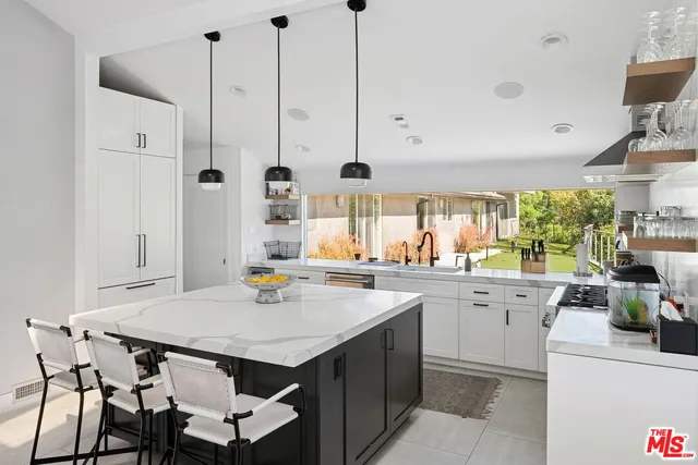 a kitchen with stainless steel appliances a table chairs and white cabinets