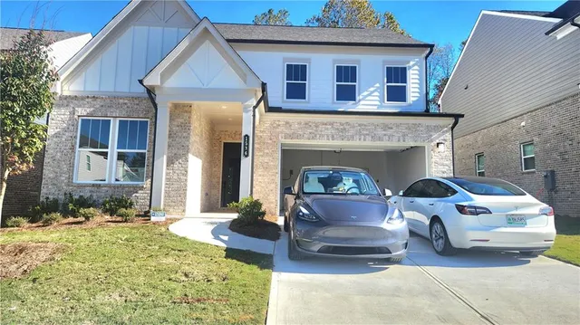 a front view of a house with a yard outdoor seating and garage