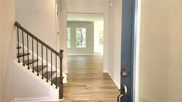 a view of a hallway with wooden floor and staircase