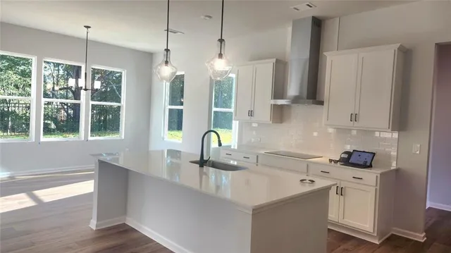 a kitchen with stainless steel appliances a sink a stove a refrigerator a counter space and cabinets