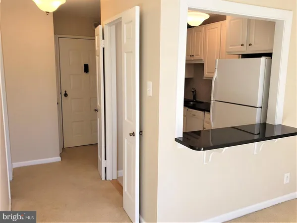 a view of kitchen with stainless steel appliances refrigerator and cabinets