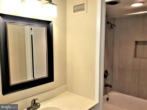 a bathroom with a tub and a mirror