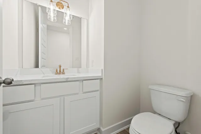 a bathroom with a granite countertop toilet sink and mirror