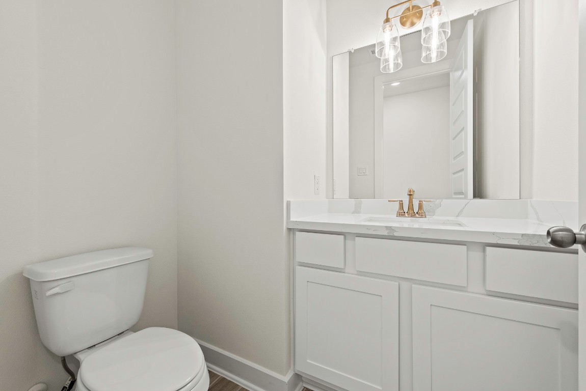 128 Meadow Beauty Lane Georgetown, TX 78633 - Photo 15 of 23 a bathroom with a granite countertop toilet sink and mirror