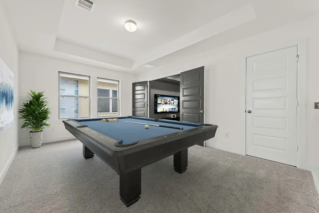 a room with pool table and windows