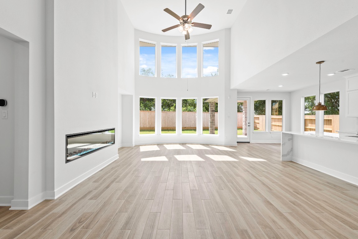 128 Meadow Beauty Lane Georgetown, TX 78633 - Photo 4 of 23 an empty room with wooden floor and windows