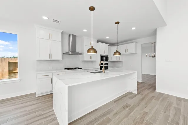 a kitchen with kitchen island a sink stainless steel appliances and cabinets