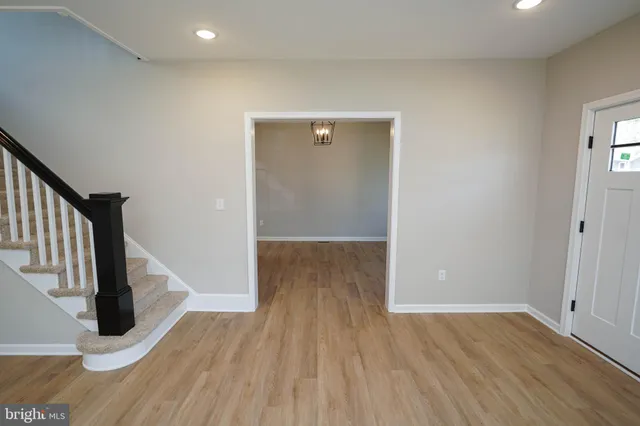 a view of a hallway with wooden floor and staircase