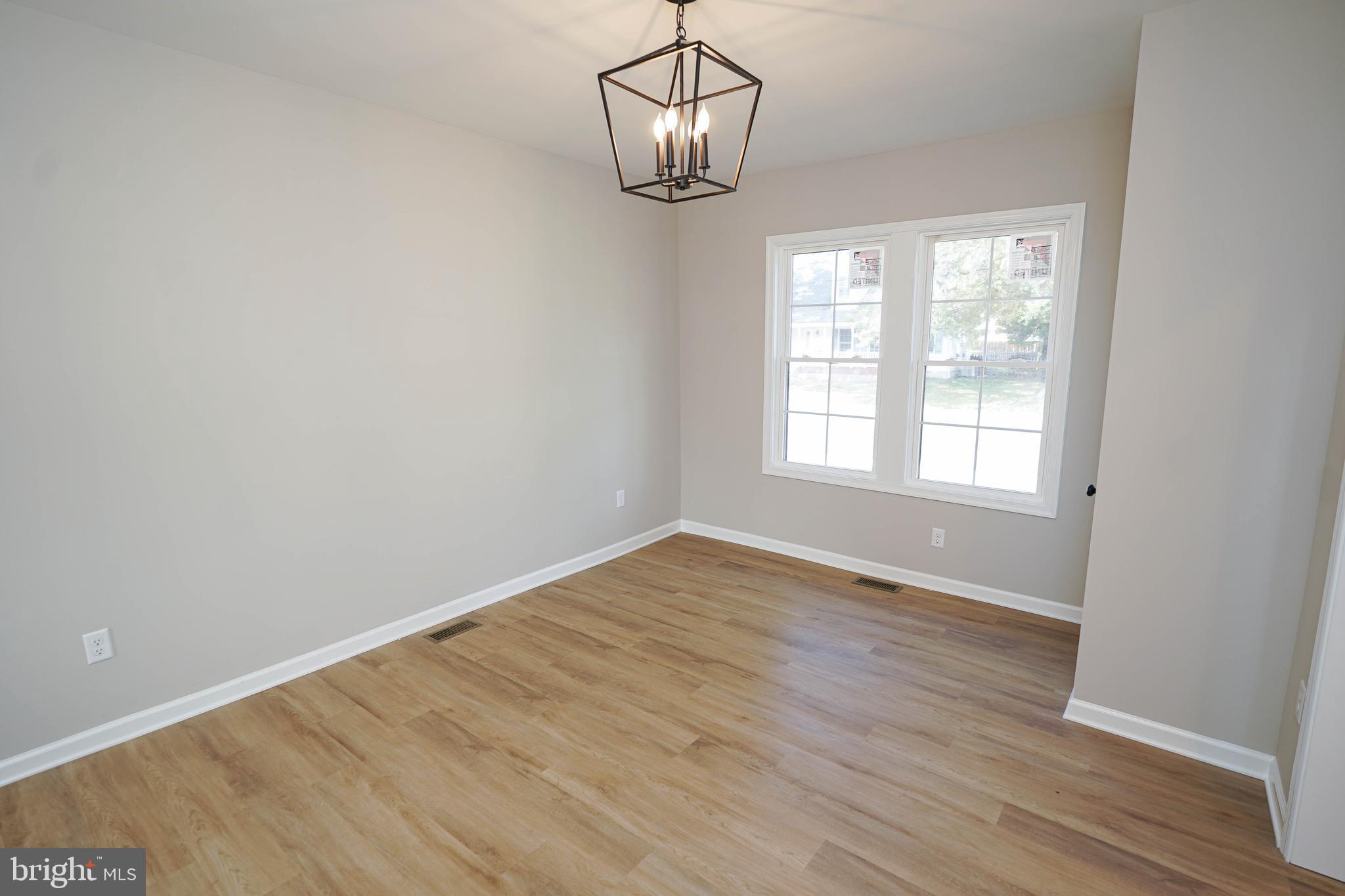 406 Delaware Avenue Delmar, DE 19940 - Photo 14 of 48 a view of an empty room with wooden floor and a window