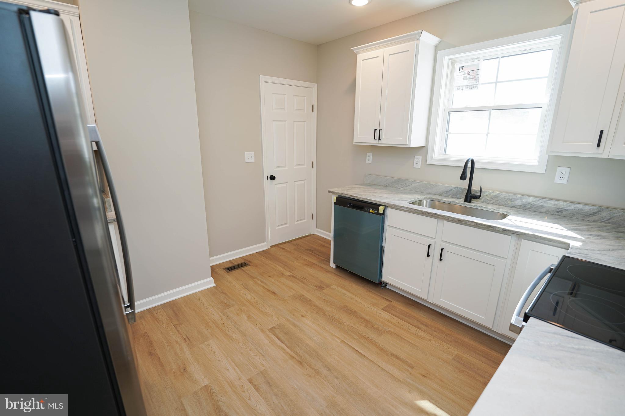 406 Delaware Avenue Delmar, DE 19940 - Photo 15 of 48 a kitchen with a sink a window and cabinets