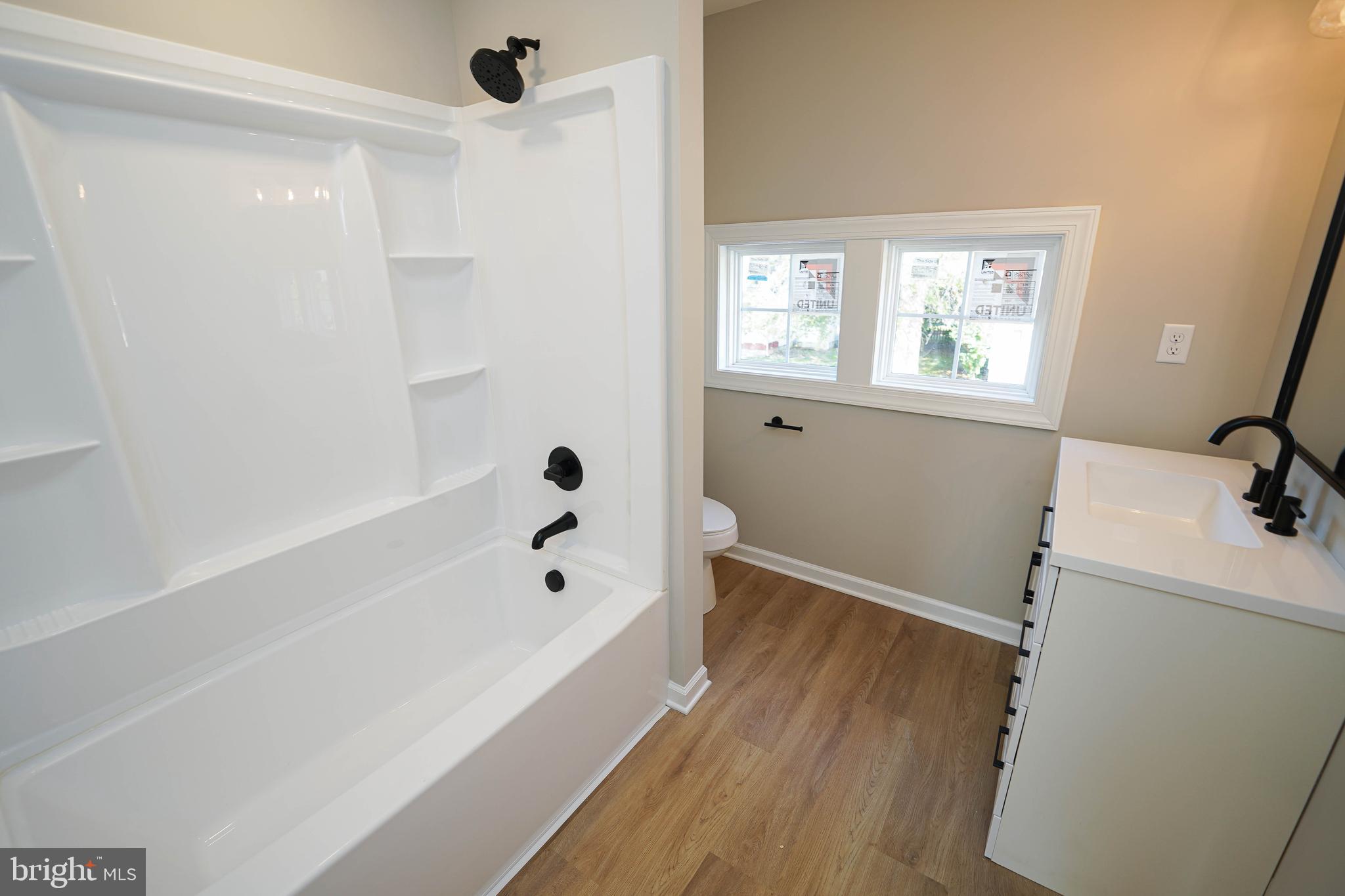 406 Delaware Avenue Delmar, DE 19940 - Photo 26 of 48 a bathroom with a bathtub a window and a shower