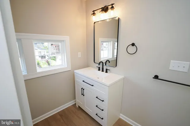 a bathroom with a double vanity sink a mirror and a window