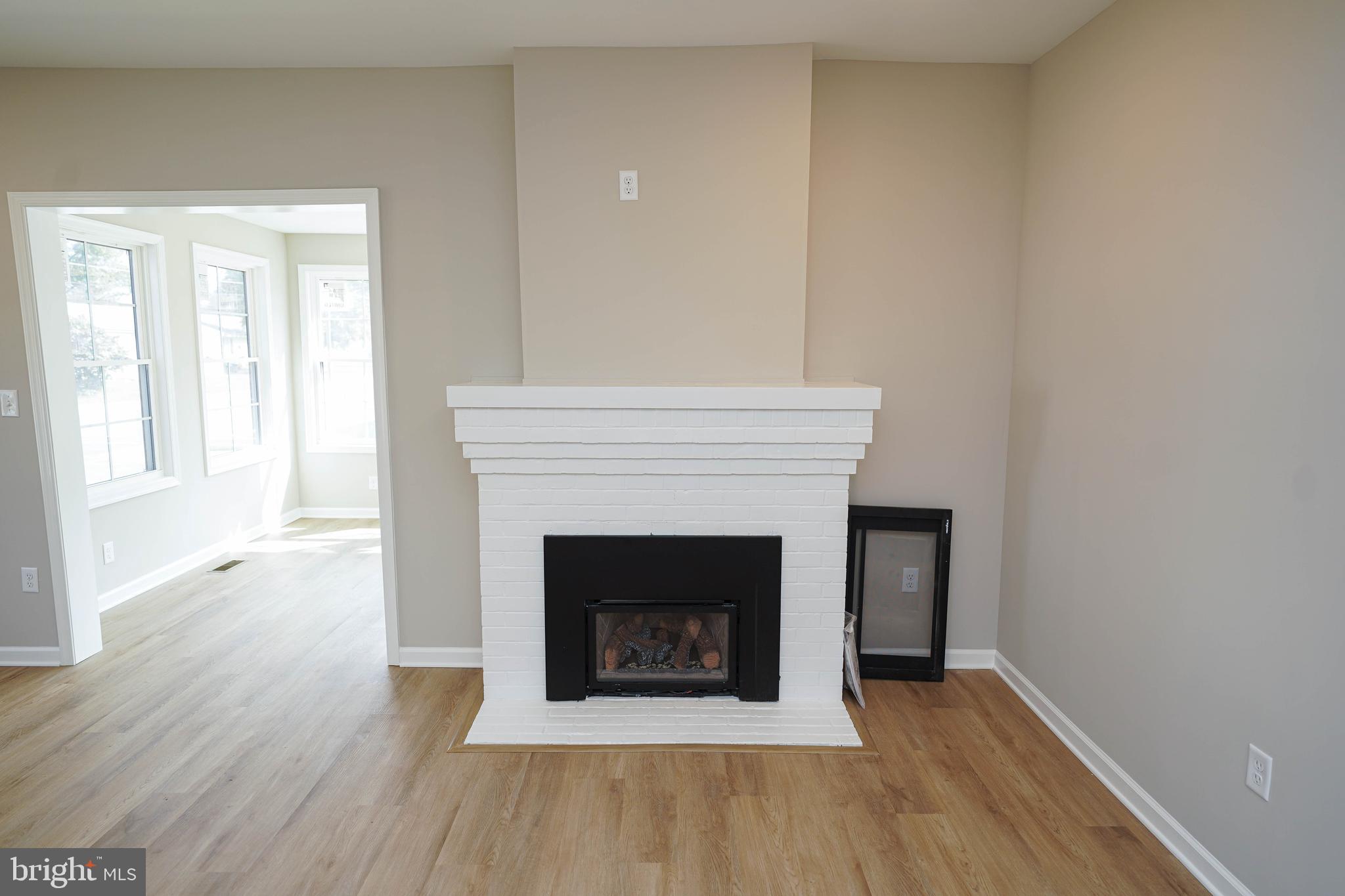 406 Delaware Avenue Delmar, DE 19940 - Photo 8 of 48 an empty room with wooden floor and fireplace