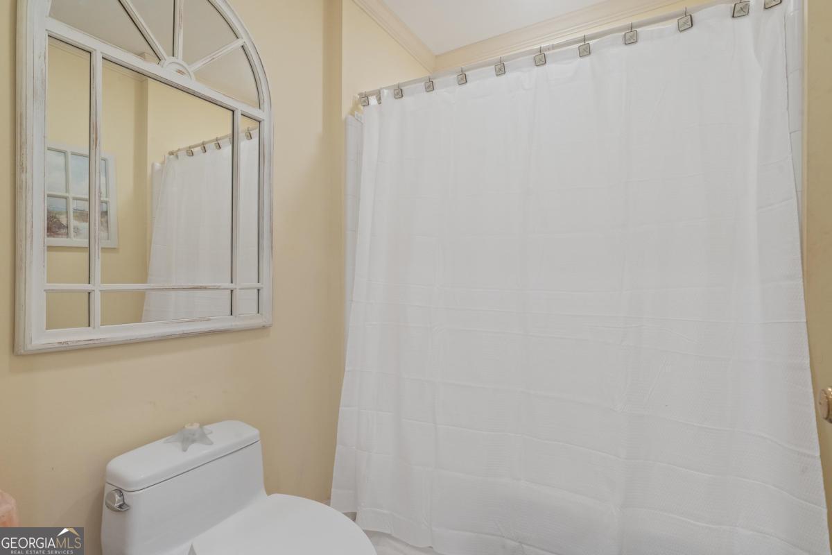 1031 Old Still Road Greensboro, GA 30642 - Photo 41 of 73 a white toilet sitting next to a shower curtain