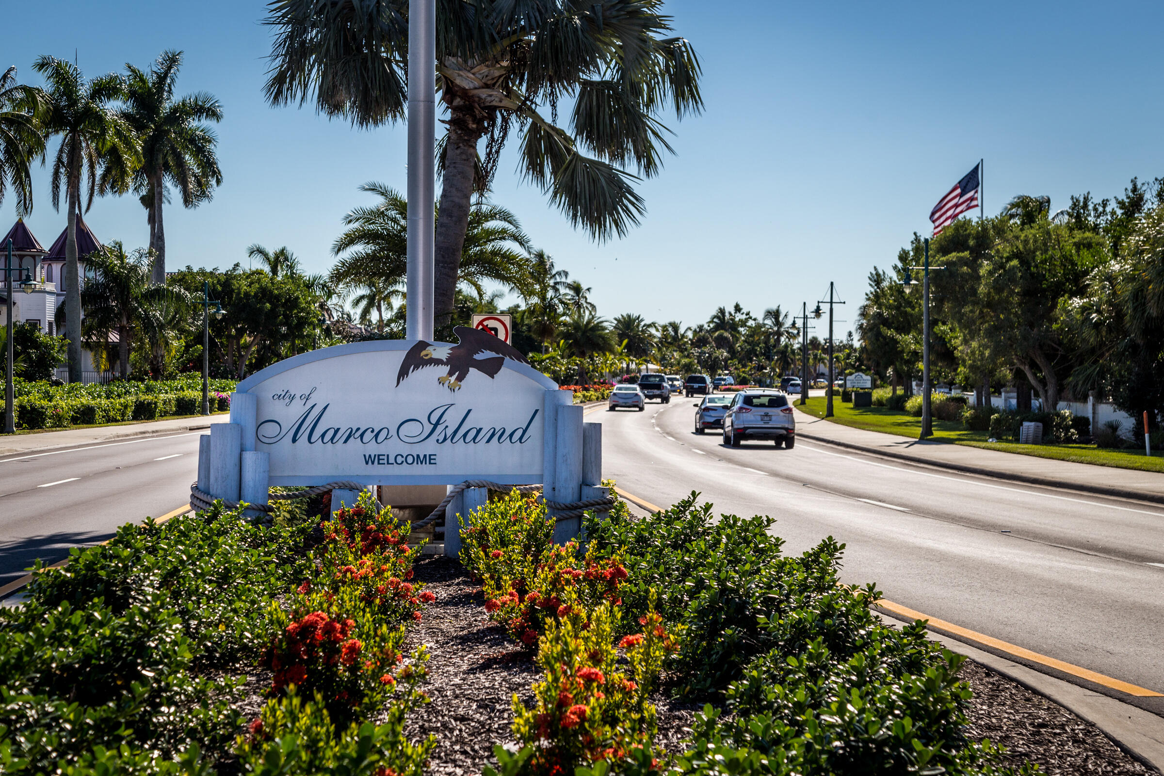 1414 Delbrook Way Marco Island, FL 34145 - Photo 20 of 21 a sign board with flower plants and wooden fence