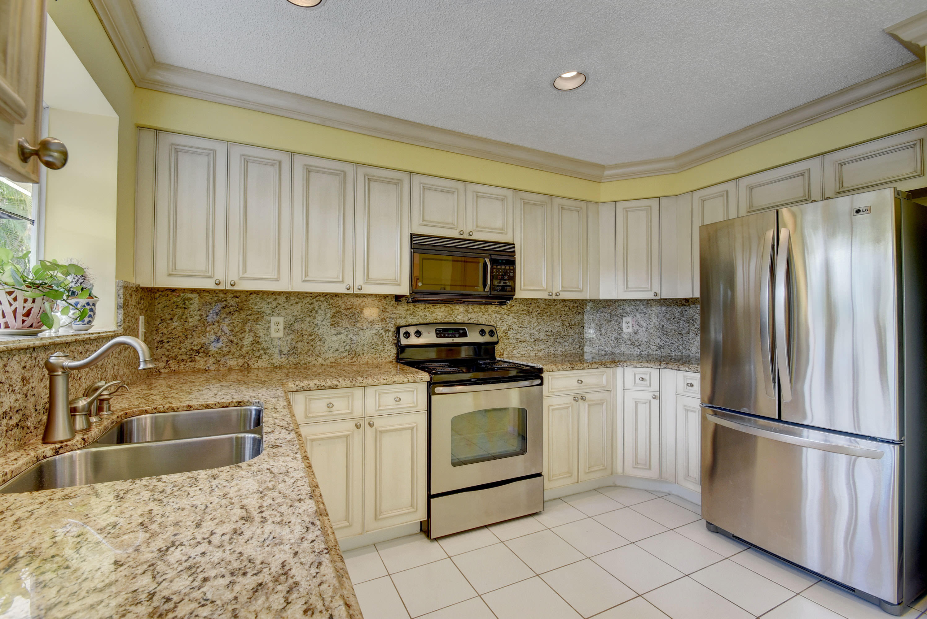 2254 Northwest 52nd Street Boca Raton, FL 33496 - Photo 11 of 28 a kitchen with granite countertop a refrigerator sink and stove