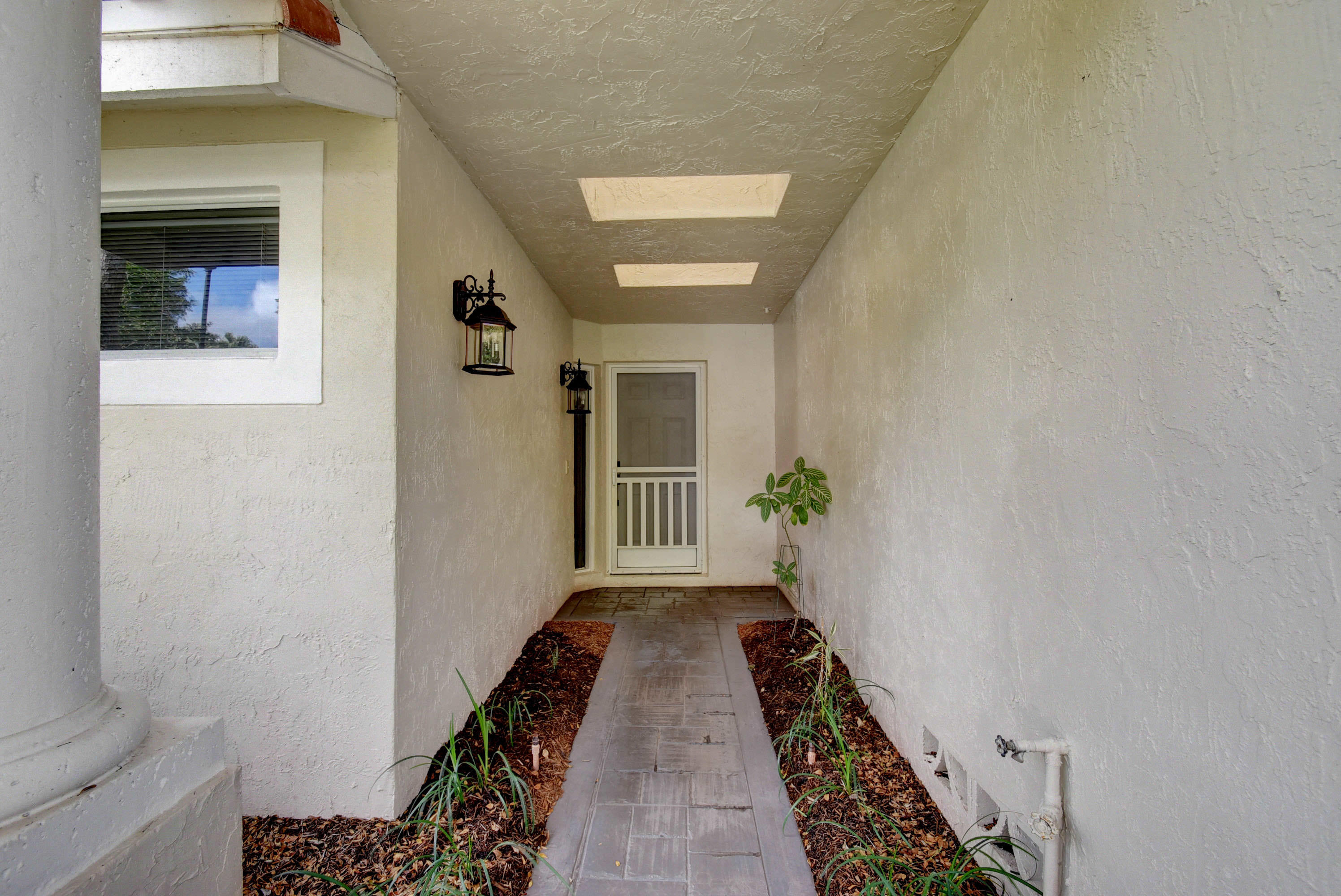 2254 Northwest 52nd Street Boca Raton, FL 33496 - Photo 4 of 28 a view of a hallway with wooden floor and a potted plant