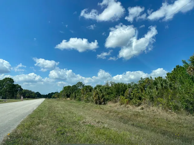 a view of a area with a tree and red fence