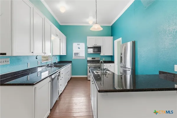 a large kitchen with a refrigerator a stove top oven a sink and dishwasher