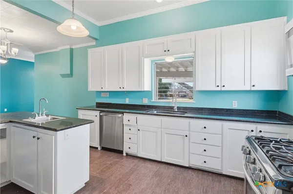 a kitchen with granite countertop white cabinets and white appliances