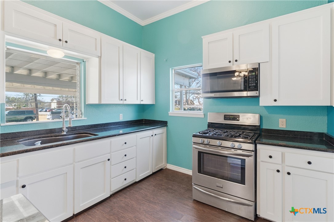 222 East Cedar Street Seguin, TX 78155 - Photo 16 of 46 a kitchen with granite countertop white cabinets and white appliances