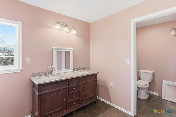 a bathroom with a toilet sink and mirror