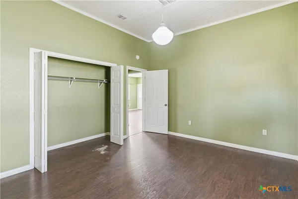 an empty room with a ceiling fan and wooden floor