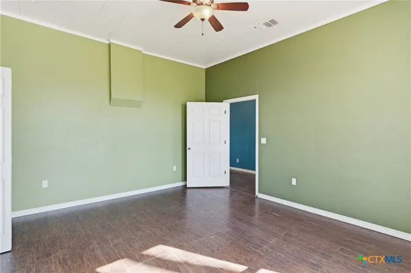 a view of an empty room with window and wooden floor