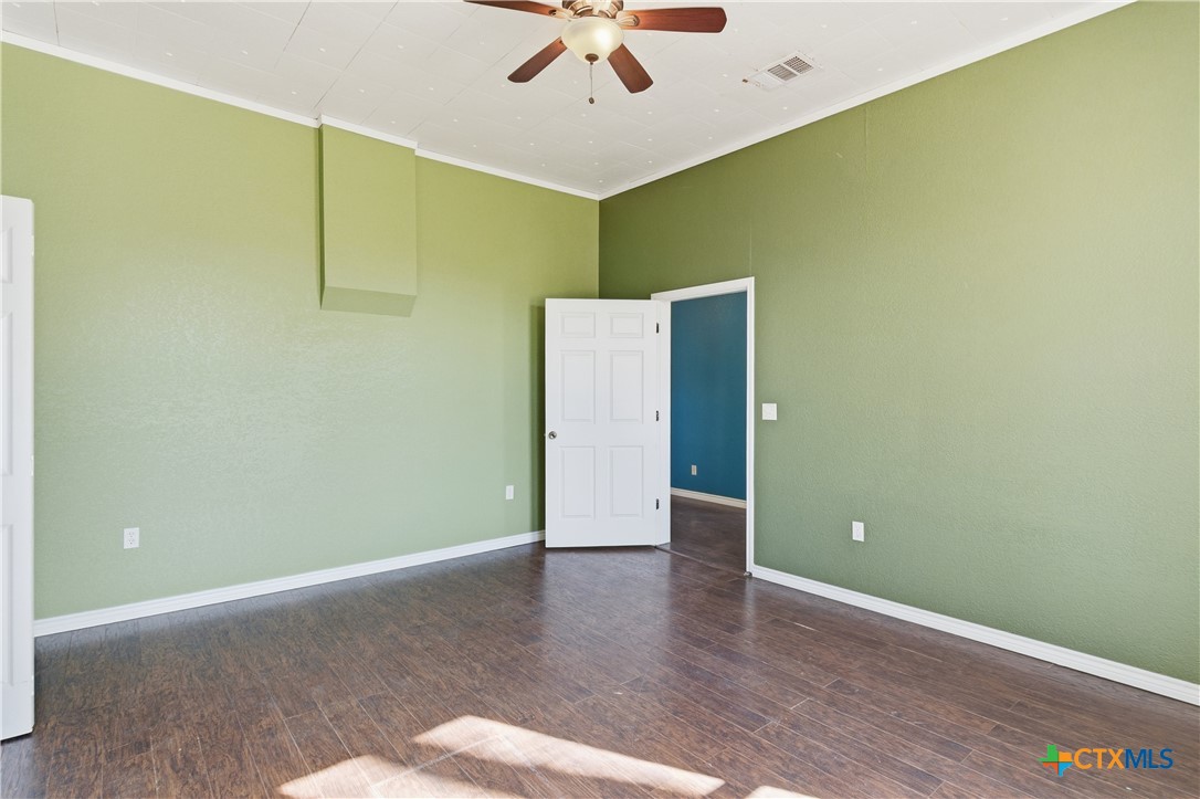 222 East Cedar Street Seguin, TX 78155 - Photo 30 of 46 an empty room with a ceiling fan and wooden floor
