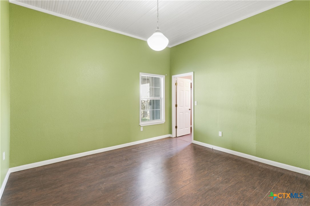 222 East Cedar Street Seguin, TX 78155 - Photo 32 of 46 an empty room with wooden floor and windows