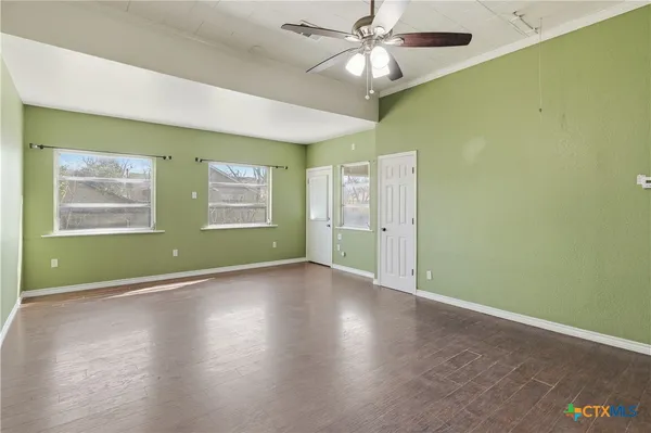a view of empty room with wooden floor
