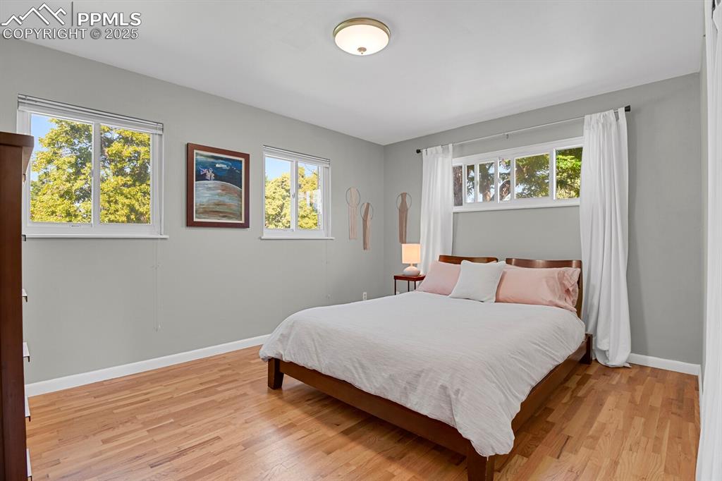 1417 Prairie Road Colorado Springs, CO 80909 - Photo 12 of 34 a bedroom with a bed and painting on the wall