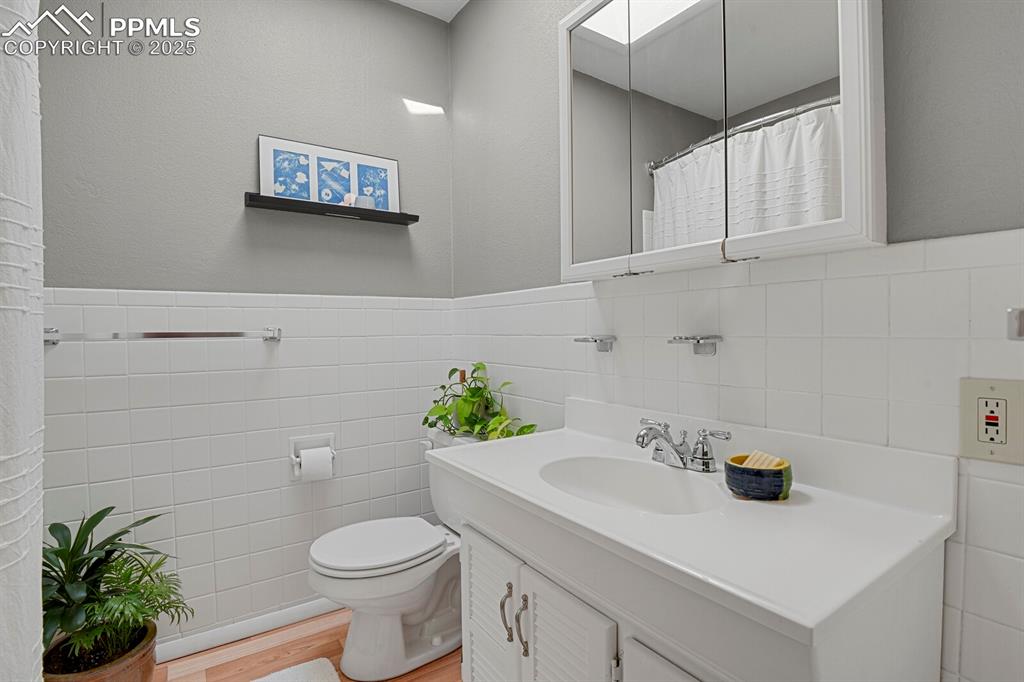 1417 Prairie Road Colorado Springs, CO 80909 - Photo 17 of 34 a bathroom with a sink a toilet and a mirror