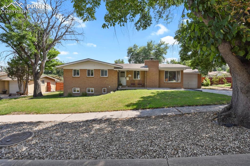 1417 Prairie Road Colorado Springs, CO 80909 - Photo 2 of 34 a front view of a house with a yard and garage