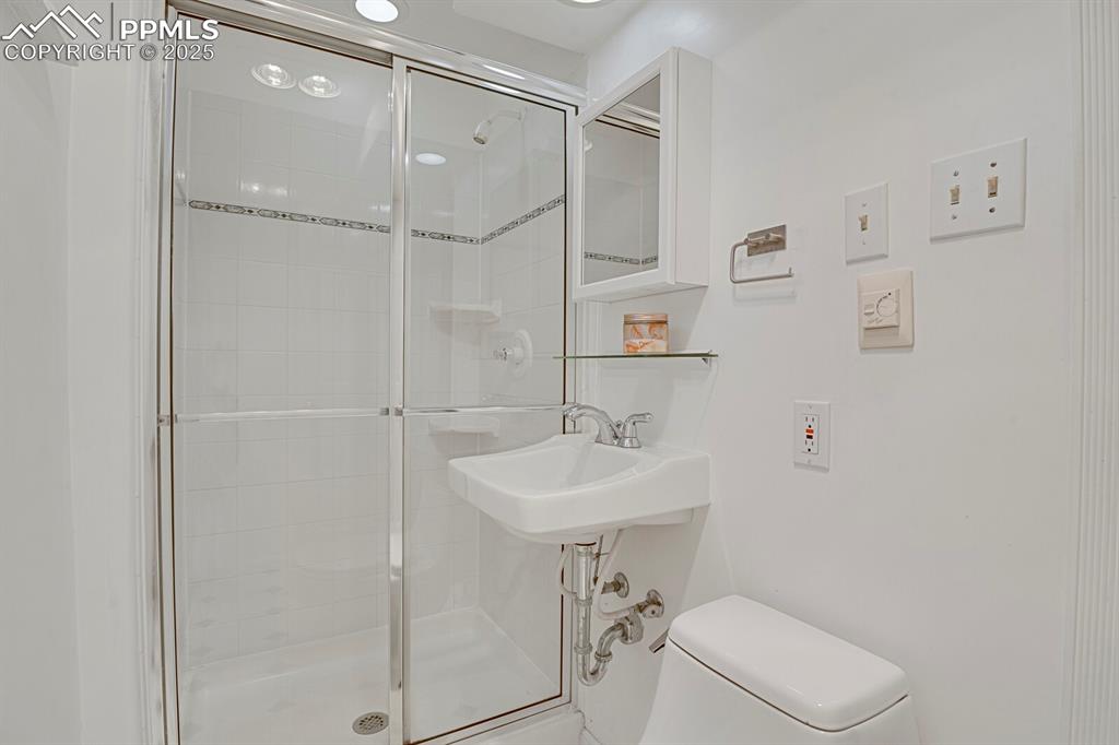 1417 Prairie Road Colorado Springs, CO 80909 - Photo 25 of 34 a bathroom with a sink a toilet and shower
