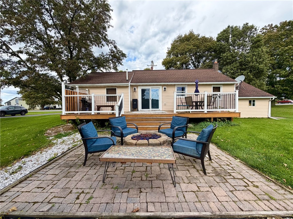Back yard showing a brick patio with a firepit hoo