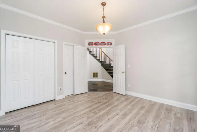 a view of a hallway with wooden floor and staircase