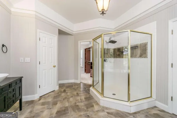 a large spacious bathroom with a tub shower and mirror
